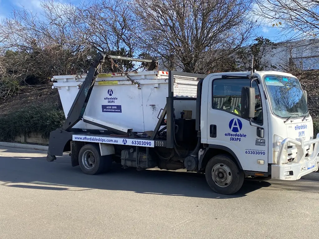 Skip bin truck parked on suburban street